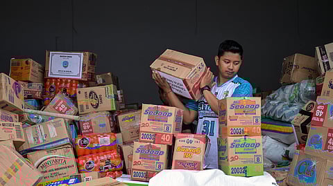 A volunteer packs supplies to be delivered to areas affected by flooding at a Regional Disaster Mitigation Agency in Sidoarjo, East Java province on December 5, 2025.