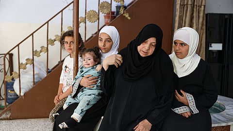Sabah al-Sheikh al-Kilani, the mother of Khaled al-Masoud, sits with several of his daughters at the family home after he was killed during a raid in the town of al-Dumayr, in the Damascus countryside, Syria, Oct. 28, 2025